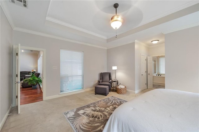 bedroom featuring ensuite bath, ceiling fan, ornamental molding, light carpet, and a raised ceiling