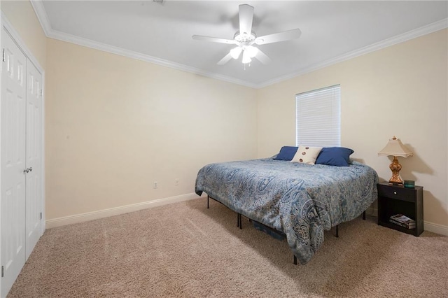 carpeted bedroom featuring crown molding, a closet, and ceiling fan