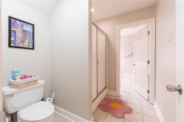 bathroom with tile patterned floors, toilet, and an enclosed shower