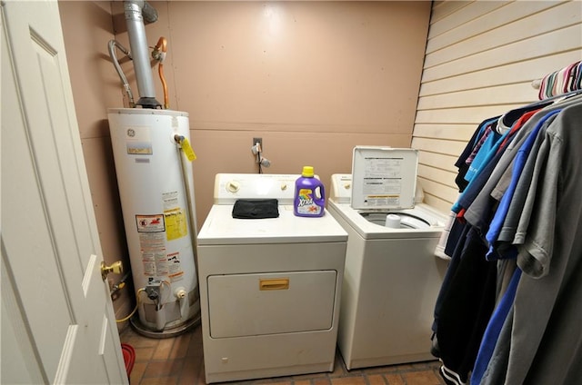 laundry room featuring gas water heater and separate washer and dryer