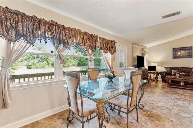 dining room with lofted ceiling and light tile patterned floors