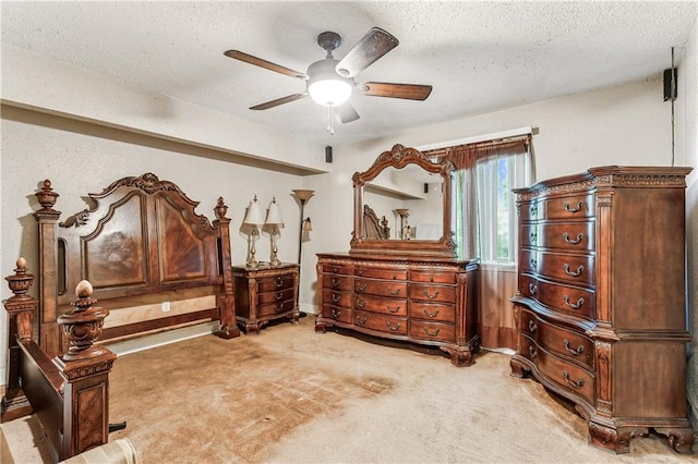 bedroom with ceiling fan, carpet, and a textured ceiling