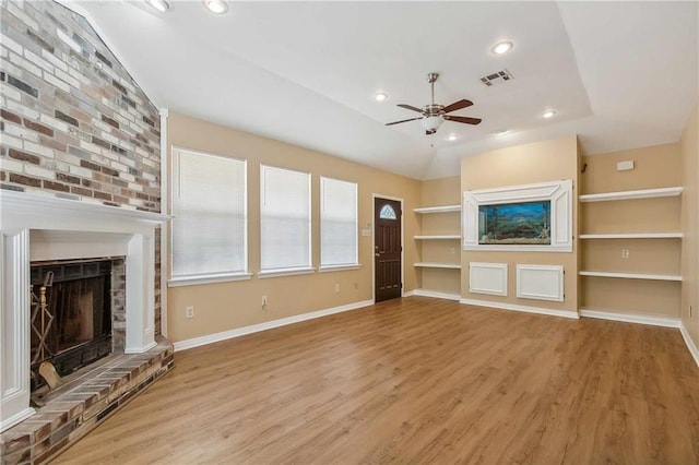 unfurnished living room with a fireplace, lofted ceiling, and light hardwood / wood-style flooring