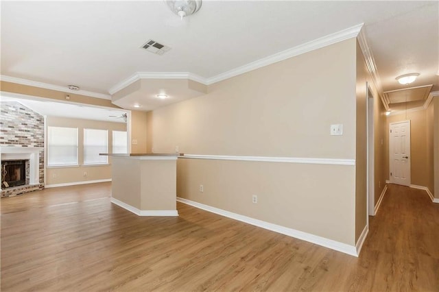 unfurnished living room featuring a brick fireplace, ceiling fan, hardwood / wood-style floors, and ornamental molding