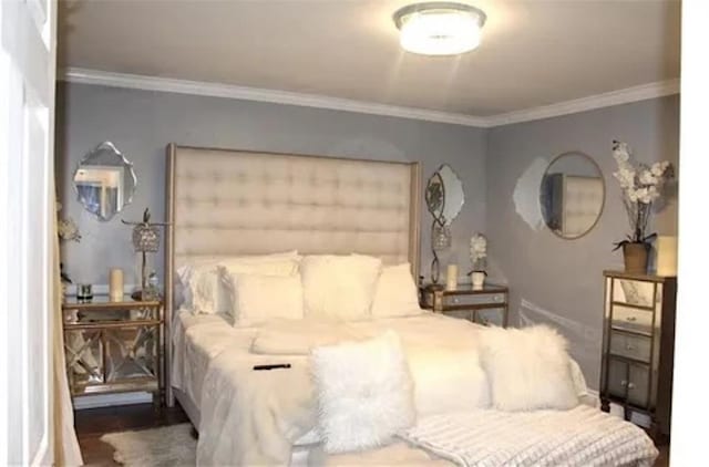 bedroom featuring wood-type flooring and crown molding