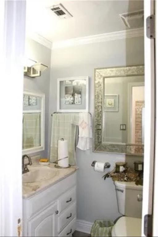 bathroom with crown molding, vanity, and toilet