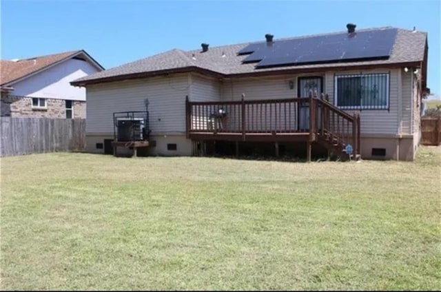 rear view of house featuring a deck and a lawn