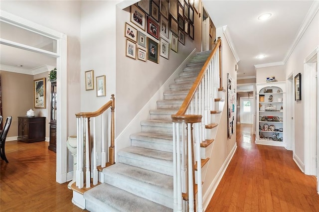 staircase featuring hardwood / wood-style floors and ornamental molding