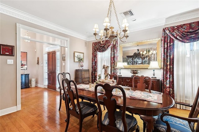 dining space featuring ornamental molding, a notable chandelier, and light hardwood / wood-style floors