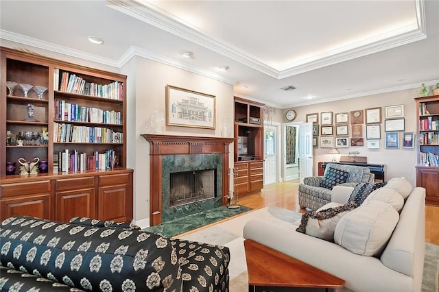 living room featuring a premium fireplace, light hardwood / wood-style floors, and ornamental molding