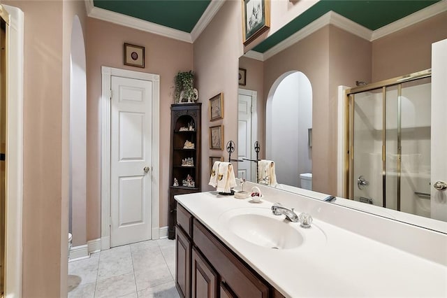 bathroom with crown molding, vanity, a shower with shower door, and tile patterned floors