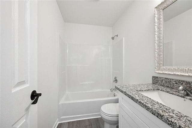 full bathroom with hardwood / wood-style floors, vanity, shower / bathtub combination, and toilet