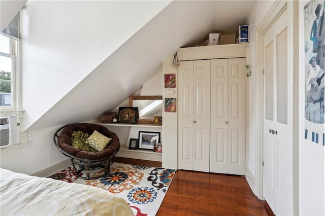 bedroom with a closet, dark hardwood / wood-style flooring, and lofted ceiling