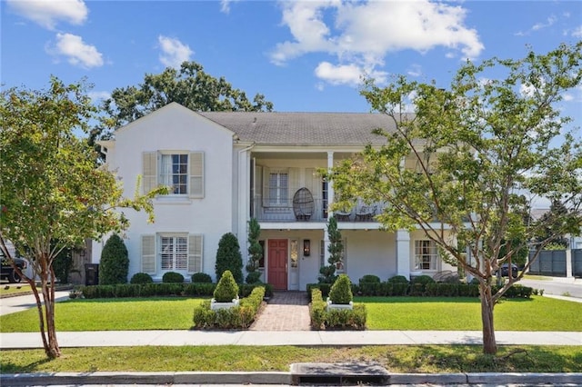 view of front of home featuring a balcony and a front yard