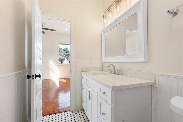 bathroom with vanity, toilet, hardwood / wood-style flooring, and ceiling fan