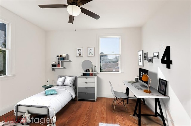 bedroom with a ceiling fan, baseboards, and wood finished floors