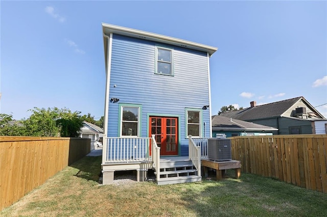 back of house featuring a lawn and central AC