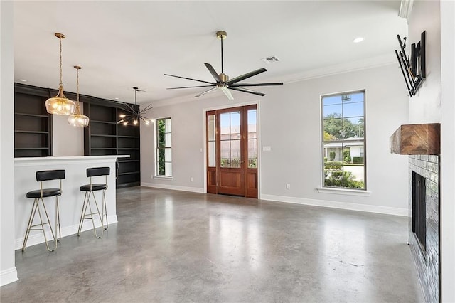 unfurnished living room featuring baseboards, visible vents, finished concrete floors, crown molding, and a fireplace