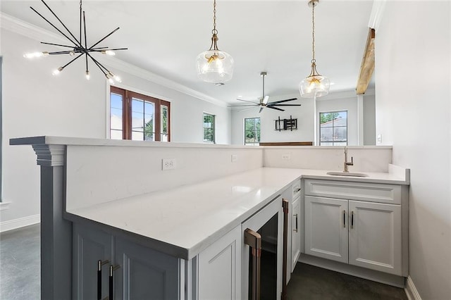 kitchen with a wealth of natural light, beverage cooler, ceiling fan with notable chandelier, and sink