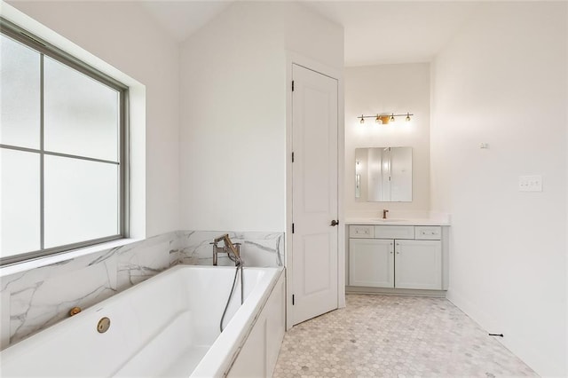 full bath featuring a soaking tub, vanity, and tile patterned floors