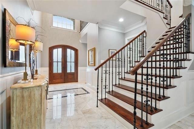 foyer entrance with french doors and ornamental molding