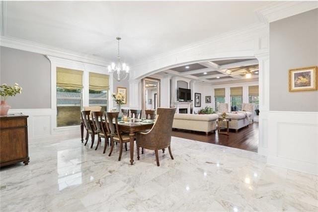 dining area with beam ceiling, coffered ceiling, ornamental molding, a notable chandelier, and hardwood / wood-style flooring