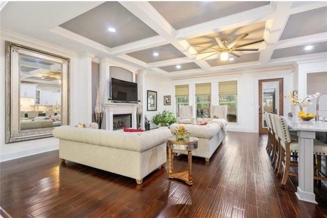 living room with beam ceiling, ceiling fan, dark wood-type flooring, and coffered ceiling