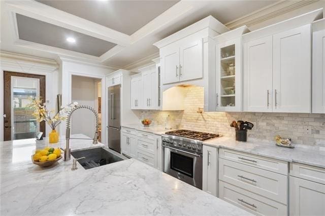 kitchen with premium appliances, white cabinetry, and sink