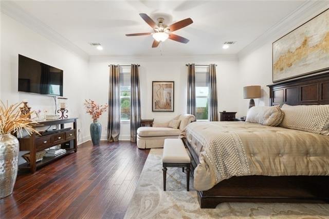 bedroom with hardwood / wood-style flooring, ceiling fan, and ornamental molding