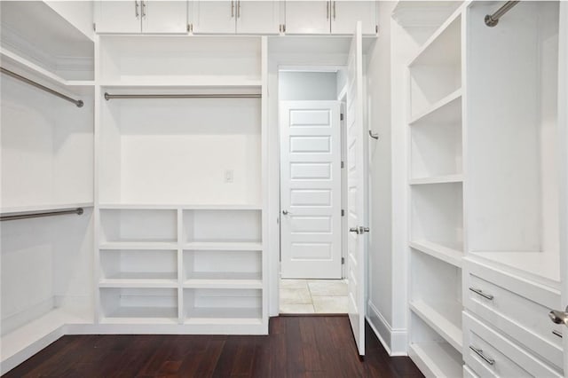 walk in closet with dark wood-type flooring