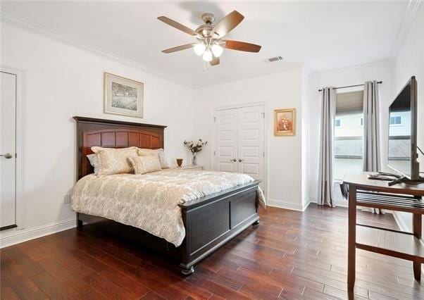 bedroom with ceiling fan, dark hardwood / wood-style flooring, ornamental molding, and a closet