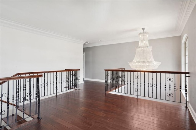 hallway with a notable chandelier, ornamental molding, and dark wood-type flooring