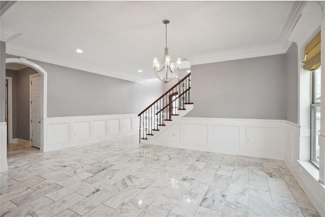 empty room with crown molding, a wealth of natural light, and a chandelier