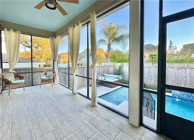 unfurnished sunroom featuring ceiling fan