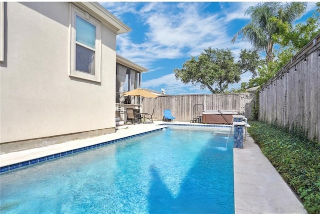 view of pool with pool water feature and a hot tub