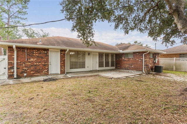 rear view of house with a yard, a patio, and central AC unit