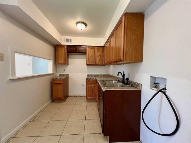 kitchen featuring light tile patterned floors and sink