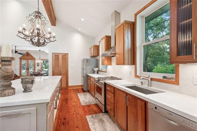 kitchen with an inviting chandelier, light hardwood / wood-style flooring, appliances with stainless steel finishes, sink, and vaulted ceiling with beams