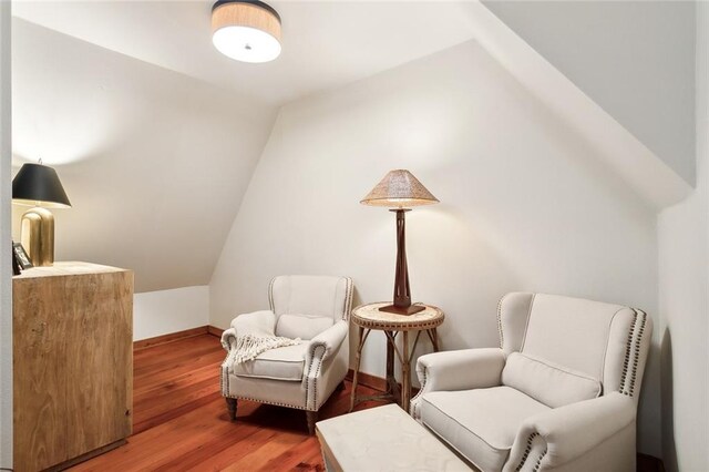 living area featuring lofted ceiling and hardwood / wood-style floors