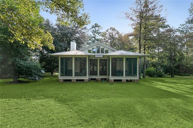 rear view of property with a yard and a sunroom