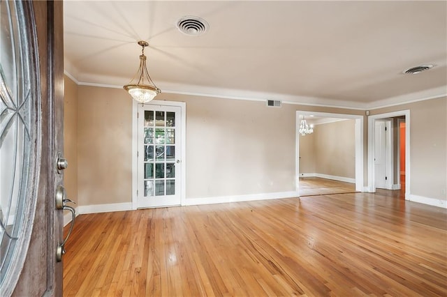 spare room featuring light hardwood / wood-style floors and crown molding