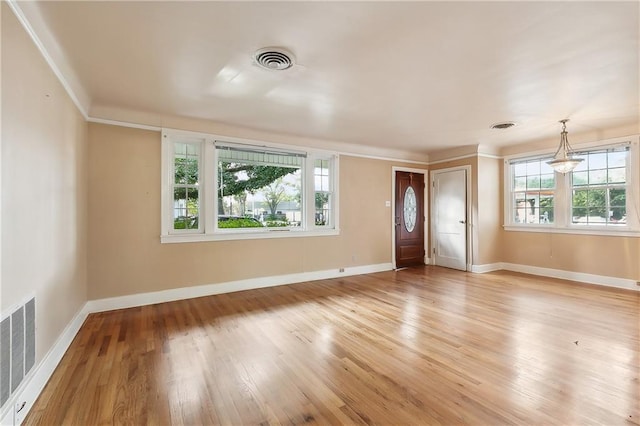 interior space featuring a wealth of natural light, light wood-type flooring, and crown molding