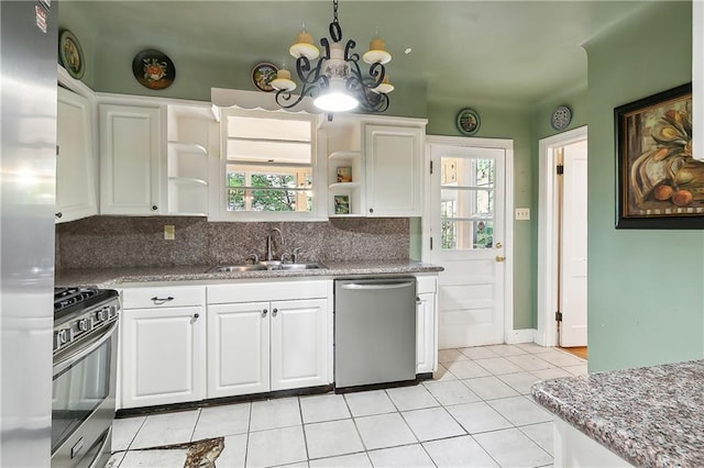 kitchen with sink, appliances with stainless steel finishes, tasteful backsplash, an inviting chandelier, and white cabinets