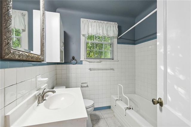 full bathroom with a wealth of natural light, tile patterned flooring, toilet, and tiled shower / bath