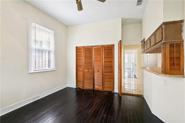 unfurnished bedroom featuring dark hardwood / wood-style floors, ceiling fan, and a closet