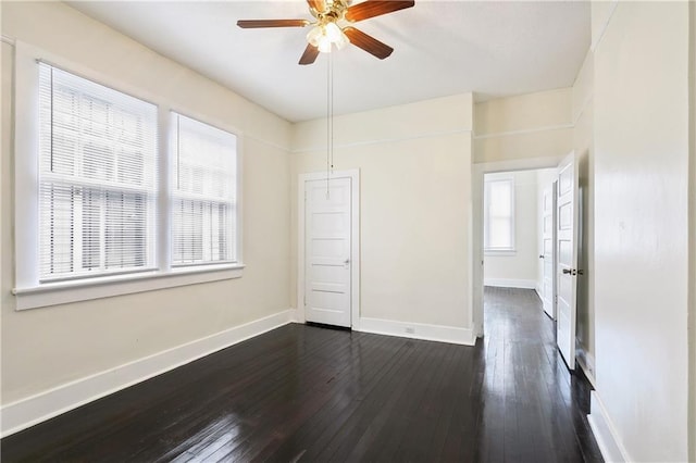 unfurnished bedroom with dark hardwood / wood-style flooring, ceiling fan, and multiple windows