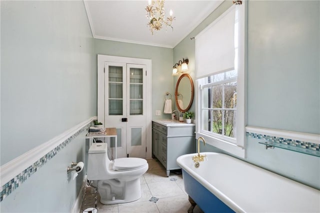 bathroom with a bathtub, vanity, ornamental molding, toilet, and tile patterned floors