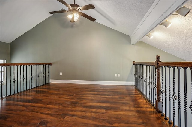 bonus room with a textured ceiling, dark wood-type flooring, ceiling fan, and vaulted ceiling with beams