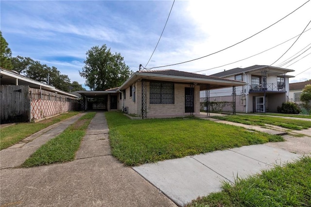 bungalow featuring a balcony, a front yard, and a carport