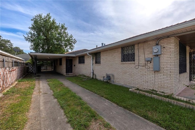 3306 Trafalgar St, New Orleans, LA 70112 - view of home's exterior featuring concrete driveway, brick siding, fence, and a carport